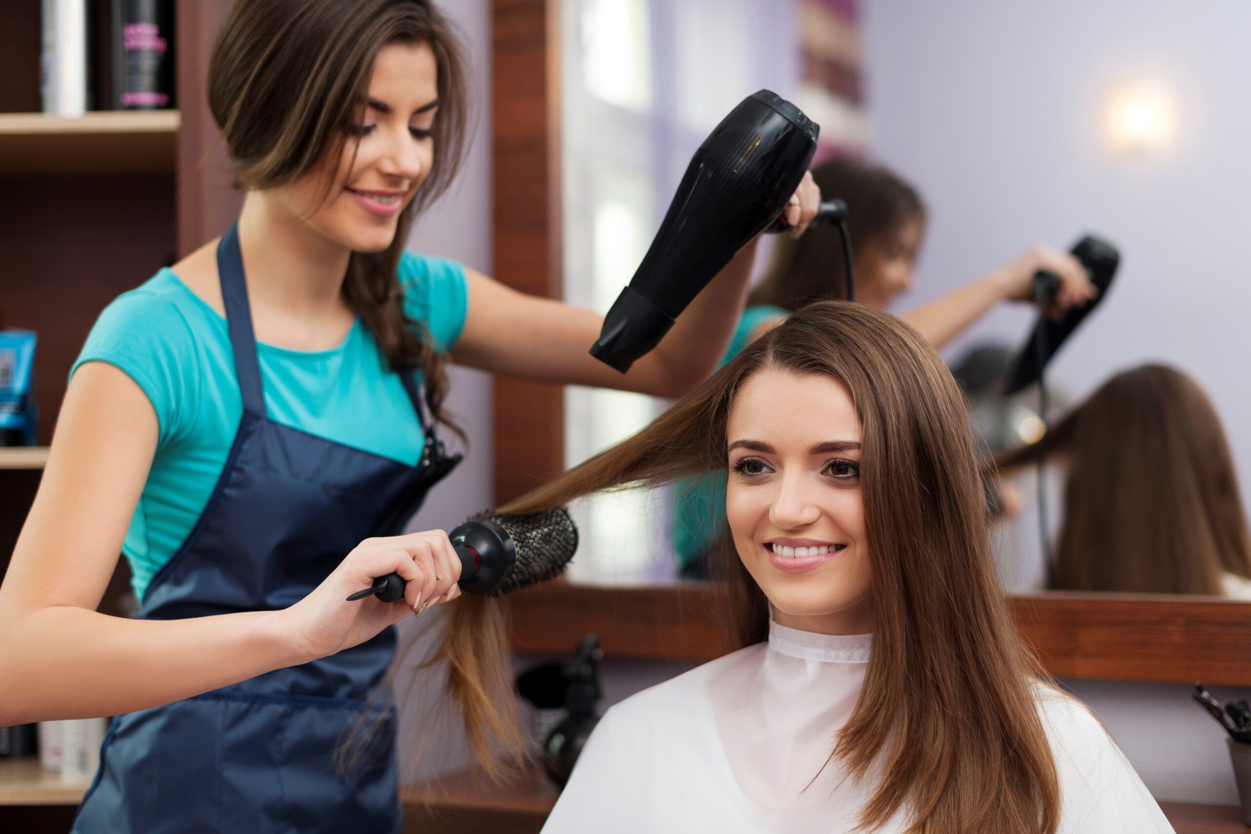 female-hairdresser-using-hairbrush-and-hair-dryer-raskrask